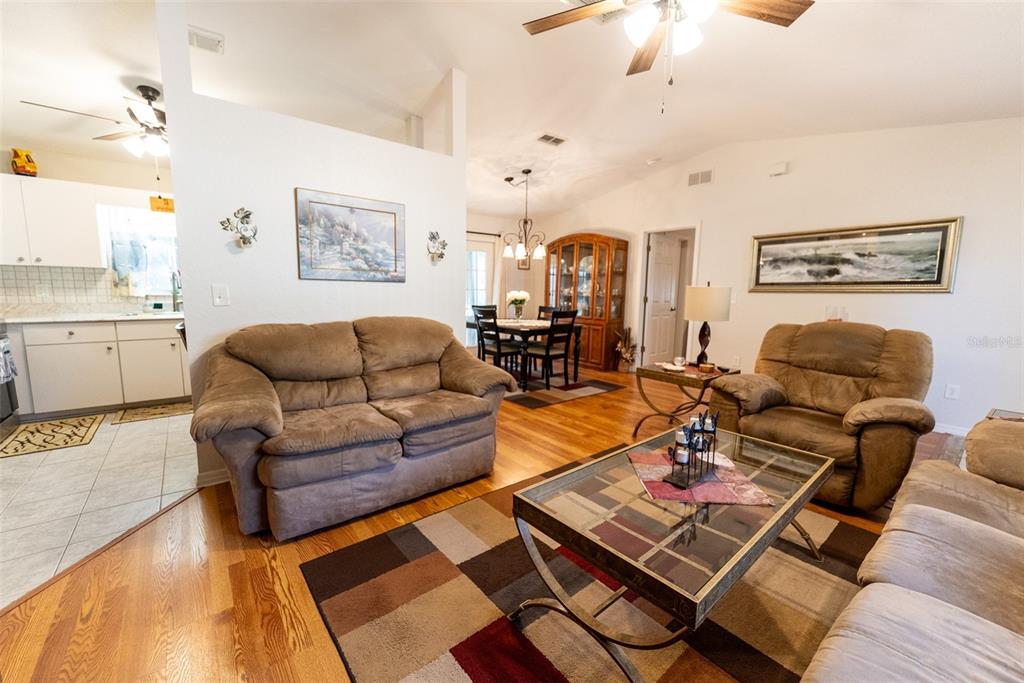 10470 Southwest 61st Terrace Road Ocala, FL 34476 - Photo 16 of 63 a living room with furniture a rug and a chandelier