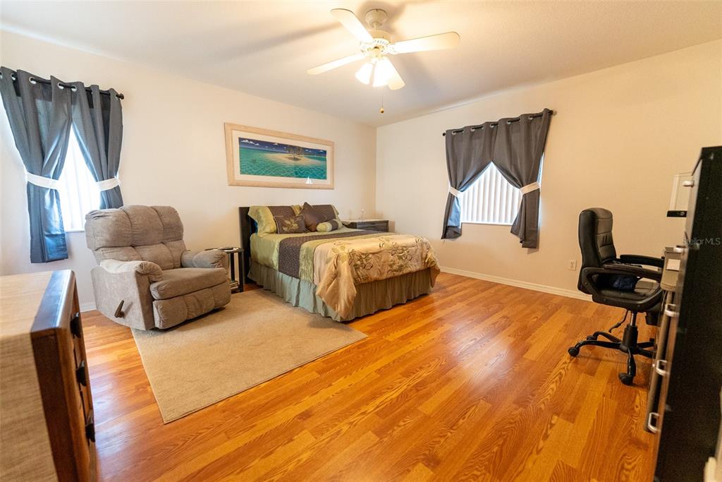 10470 Southwest 61st Terrace Road Ocala, FL 34476 - Photo 29 of 63 a spacious bedroom with a bed and a chandelier