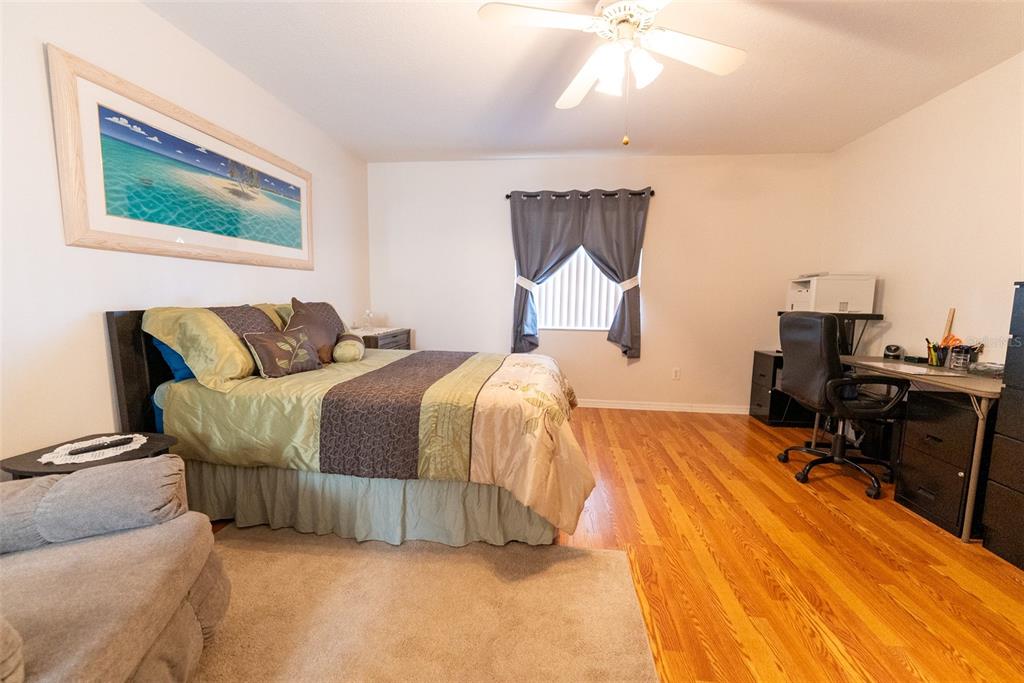 10470 Southwest 61st Terrace Road Ocala, FL 34476 - Photo 34 of 63 a bedroom with a bed and wooden floor