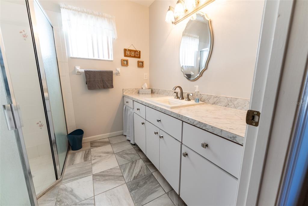 10470 Southwest 61st Terrace Road Ocala, FL 34476 - Photo 35 of 63 a spacious bathroom with a granite countertop sink a mirror and a bathtub