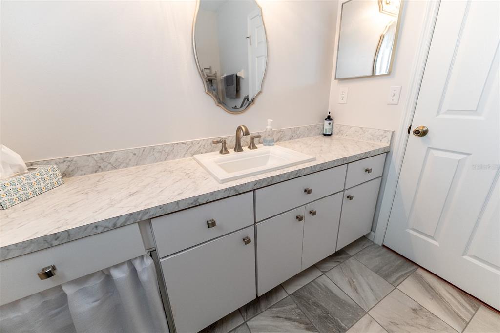 10470 Southwest 61st Terrace Road Ocala, FL 34476 - Photo 38 of 63 a bathroom with a double vanity sink and mirror