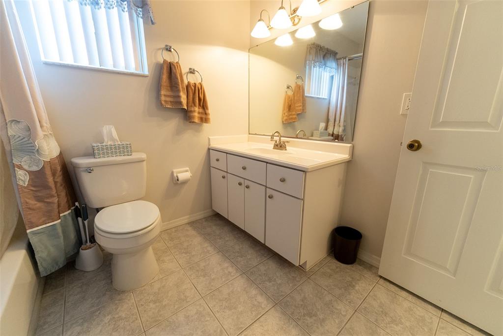 10470 Southwest 61st Terrace Road Ocala, FL 34476 - Photo 42 of 63 a bathroom with a toilet sink vanity and mirror