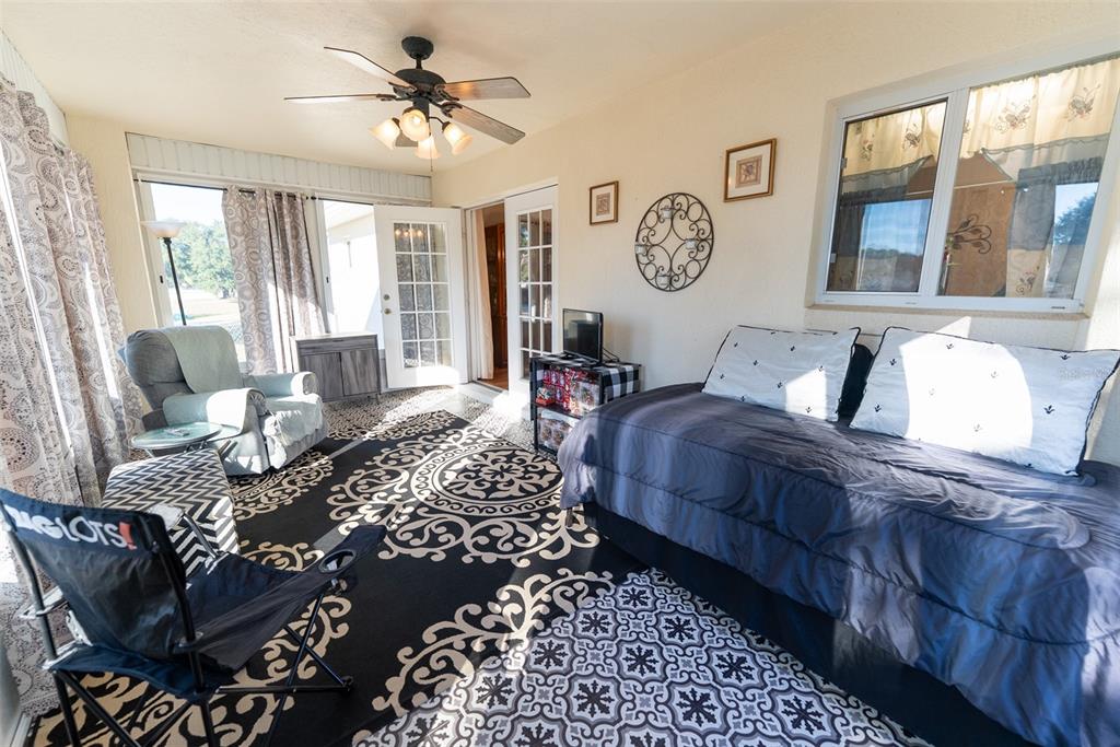 10470 Southwest 61st Terrace Road Ocala, FL 34476 - Photo 51 of 63 a living room with furniture two windows and a chandelier