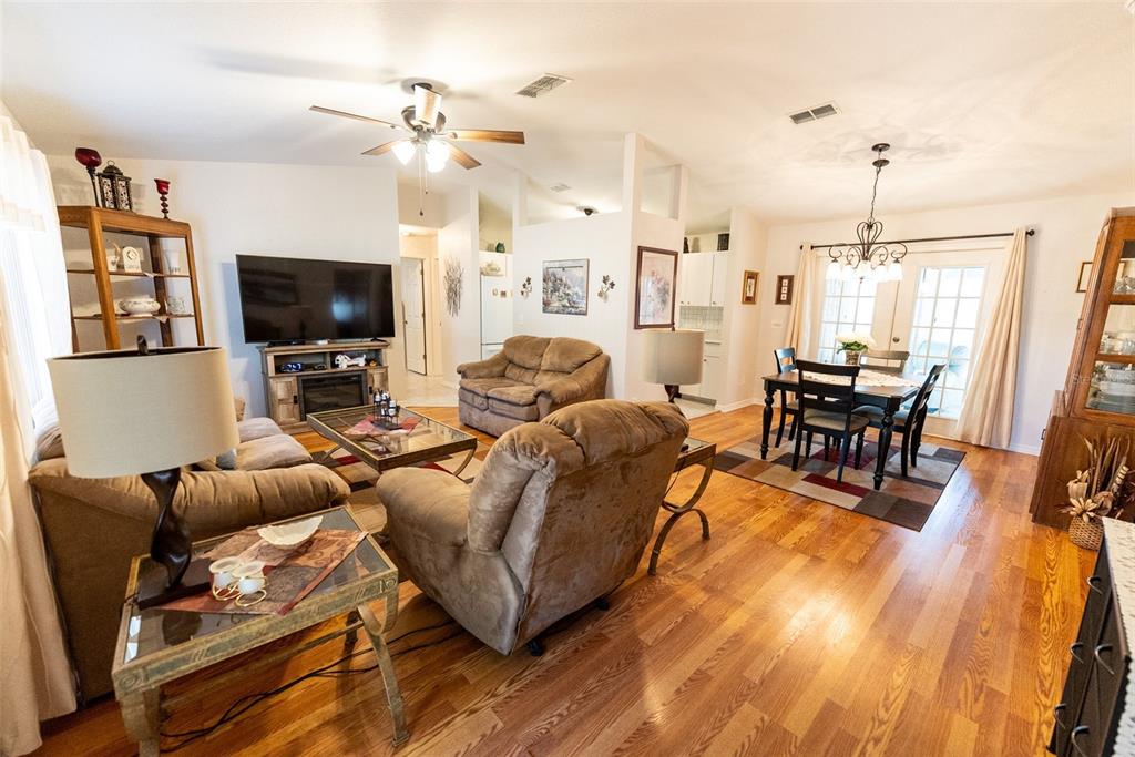 10470 Southwest 61st Terrace Road Ocala, FL 34476 - Photo 10 of 63 a living room with furniture a flat screen tv and kitchen view