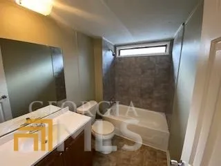 a bathroom with a granite countertop sink a toilet and shower
