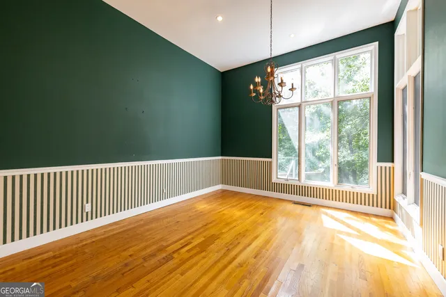 a spacious bedroom with a bed and a flat screen tv