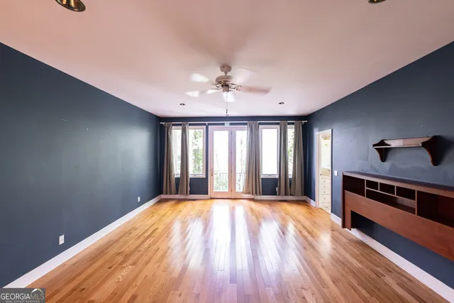 an empty room with wooden floor and windows