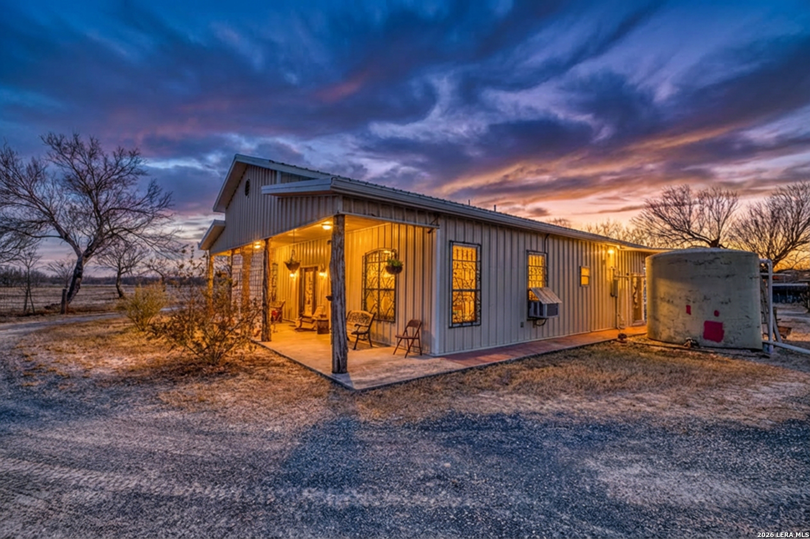 a view of a house with backyard and a tree