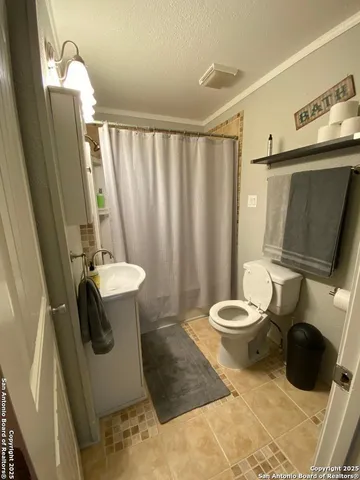 a bathroom with a toilet a sink and mirror