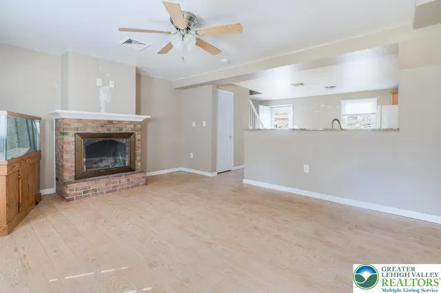 a view of empty room with fireplace and fan