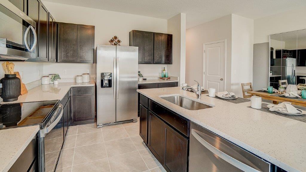 31107 Paper Birch Street Wesley Chapel, FL 33545 - Photo 8 of 15 a kitchen with stainless steel appliances a sink stove and refrigerator