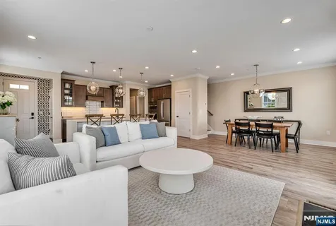 a living room with furniture and a dining table with kitchen view