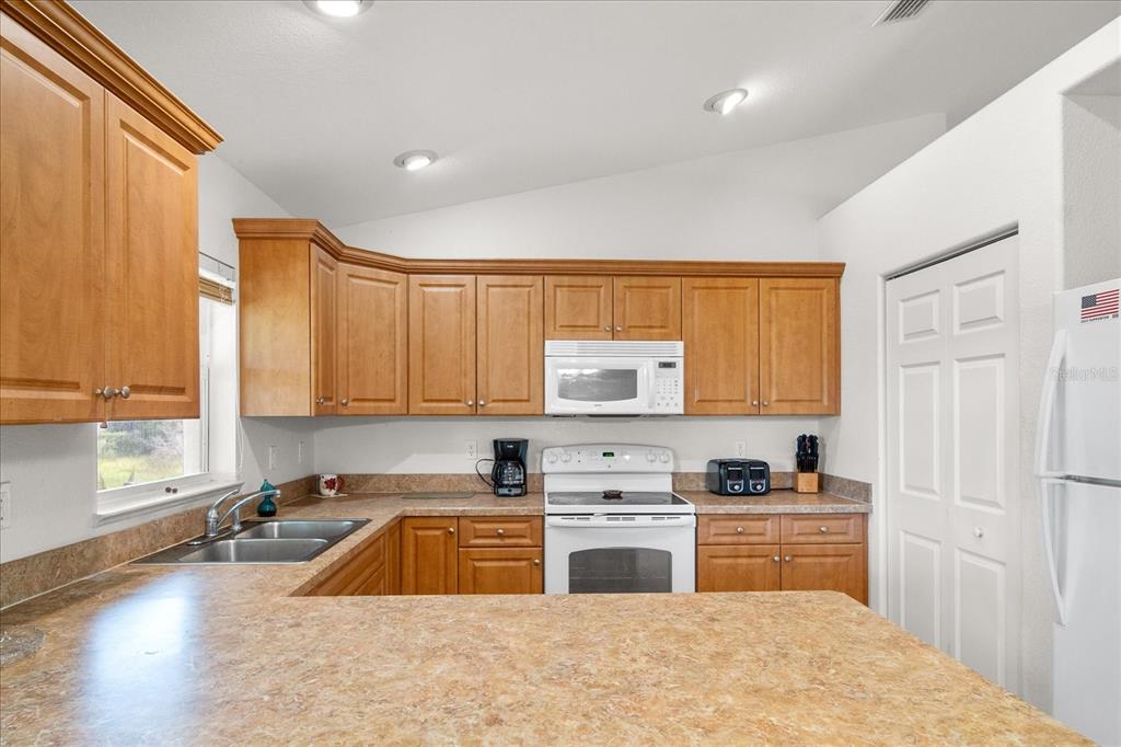 30 Milky Way Venus, FL 33960 - Photo 12 of 47 a kitchen with stainless steel appliances a sink a stove a microwave a sink and cabinets