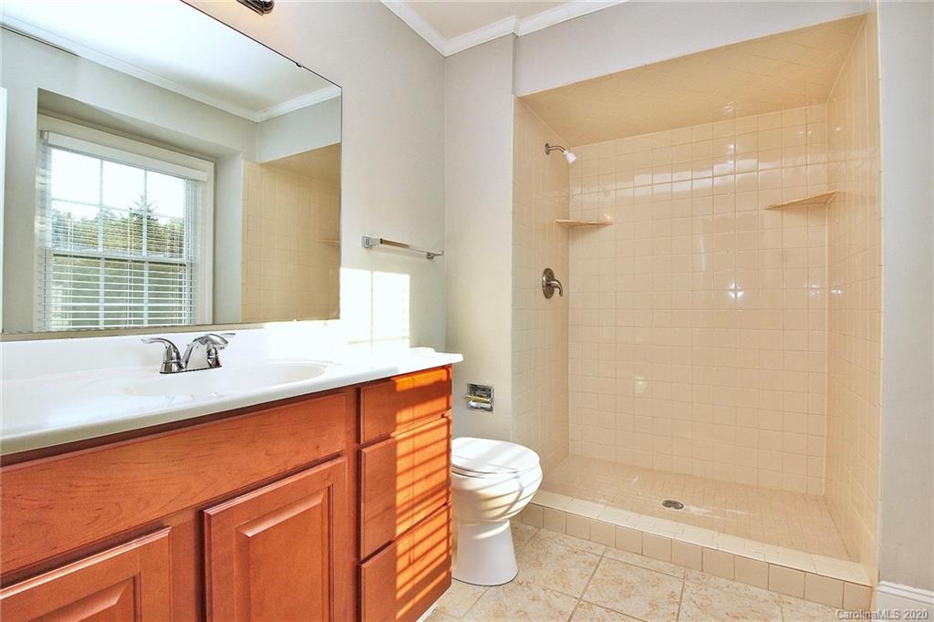 4312 Carmel Road Charlotte, NC 28226 - Photo 19 of 36 a bathroom with a sink a toilet a large mirror and shower