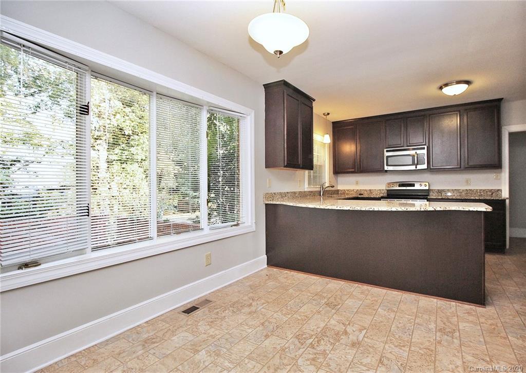 4312 Carmel Road Charlotte, NC 28226 - Photo 7 of 36 a kitchen with kitchen island granite countertop a stove a sink a counter space and a window