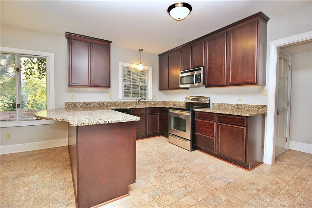 4312 Carmel Road Charlotte, NC 28226 - Photo 9 of 36 a kitchen with stainless steel appliances granite countertop wooden cabinets a sink and dishwasher a stove with wooden floor