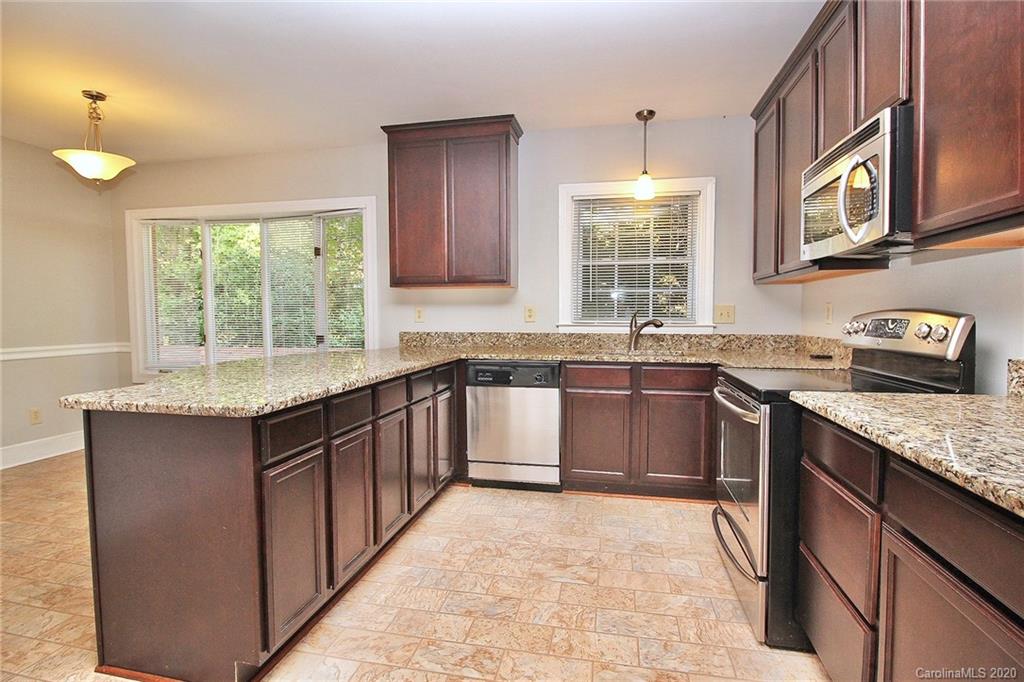 4312 Carmel Road Charlotte, NC 28226 - Photo 10 of 36 a kitchen with stainless steel appliances granite countertop a sink stove and cabinets