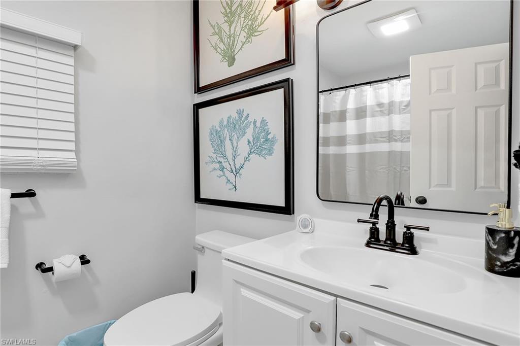 2780 Weeks Avenue Naples, FL 34112 - Photo 13 of 34 a bathroom with a sink a toilet and a mirror