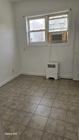 a view of a livingroom with an empty space and a window