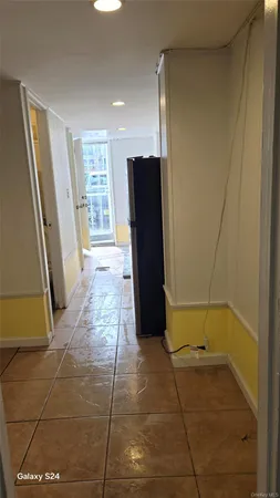 a view of a hallway with wooden floor and a bathroom