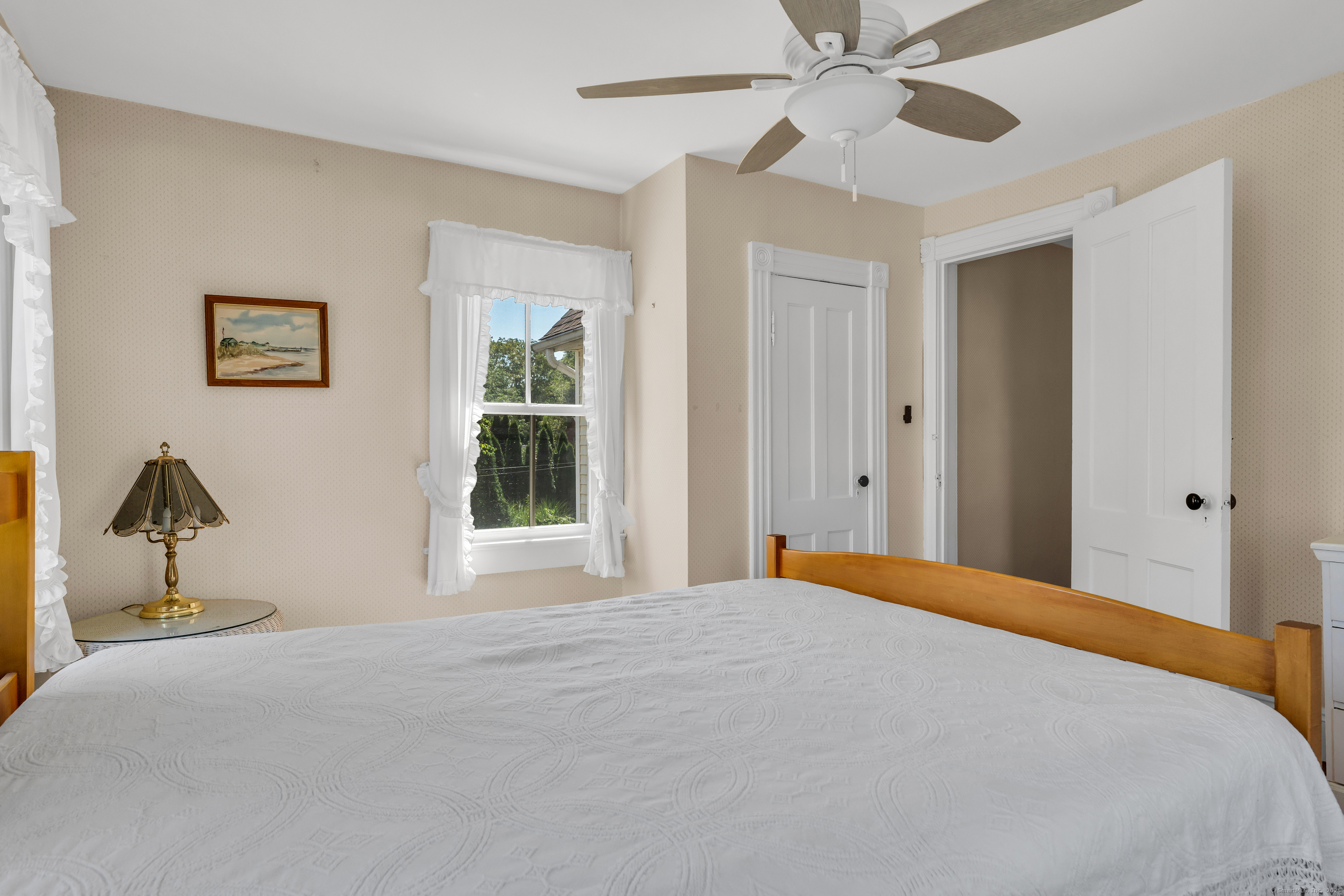 13 Waterside Lane Clinton, CT 06413 - Photo 29 of 40 a bedroom with a bed and a chandelier