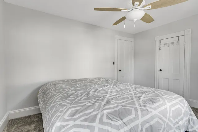 a bedroom with a bed and a chandelier fan