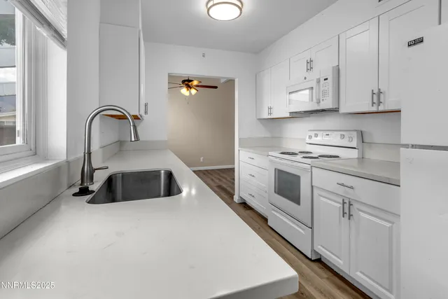 a kitchen with sink a stove and cabinets