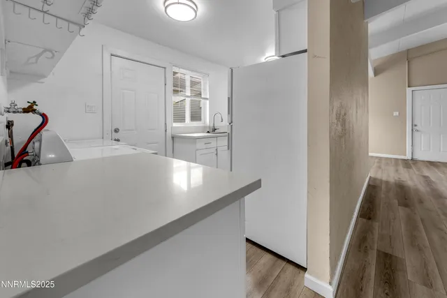 a view of a room with wooden floor and a sink