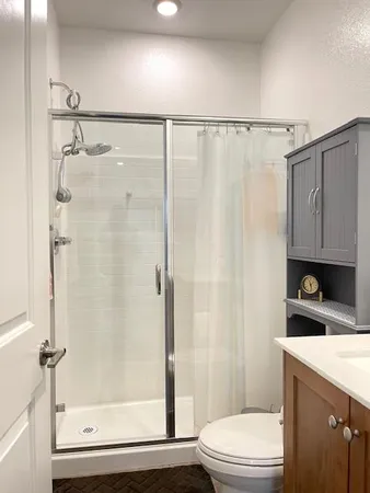 a bathroom with a shower a toilet and a sink