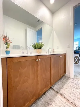 a bathroom with a double vanity sink and a mirror