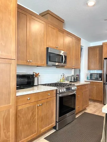a kitchen with stainless steel appliances a stove a microwave sink and cabinets