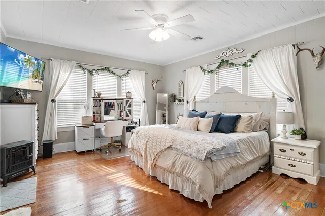 a bedroom with a bed and wooden floor