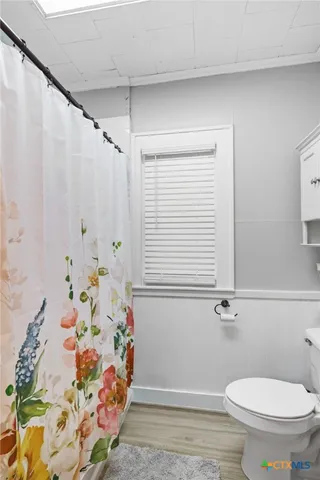 a bathroom with a toilet and a shower curtain