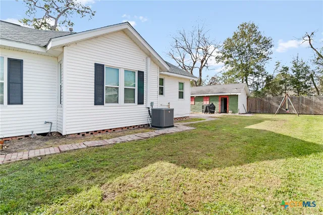 a view of a house with backyard and a tree