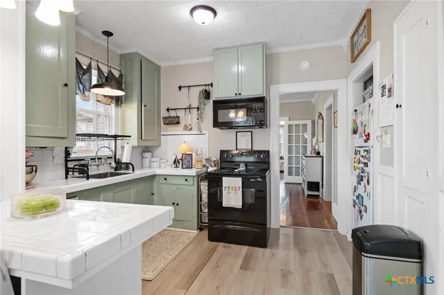 a kitchen with stainless steel appliances granite countertop a refrigerator a stove a sink dishwasher and a stove with wooden floor