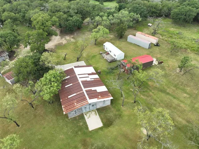 an aerial view of a house with pool yard and outdoor seating