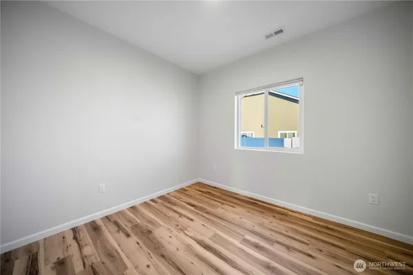 a view of a room with wooden floor and a window