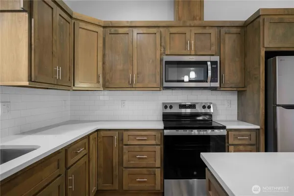 a kitchen with stainless steel appliances granite countertop a stove microwave and refrigerator