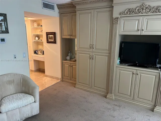 a bedroom with a bed a table and a large window