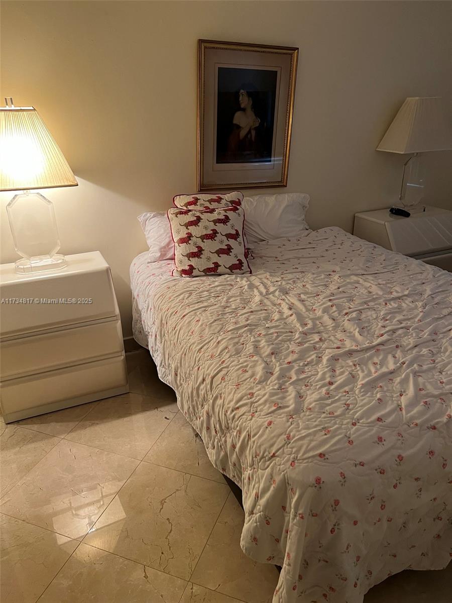 9801 Collins Avenue, Unit 17J Bal Harbour, FL 33154 - Photo 10 of 34 a bedroom with a bed and a lamp on the dresser