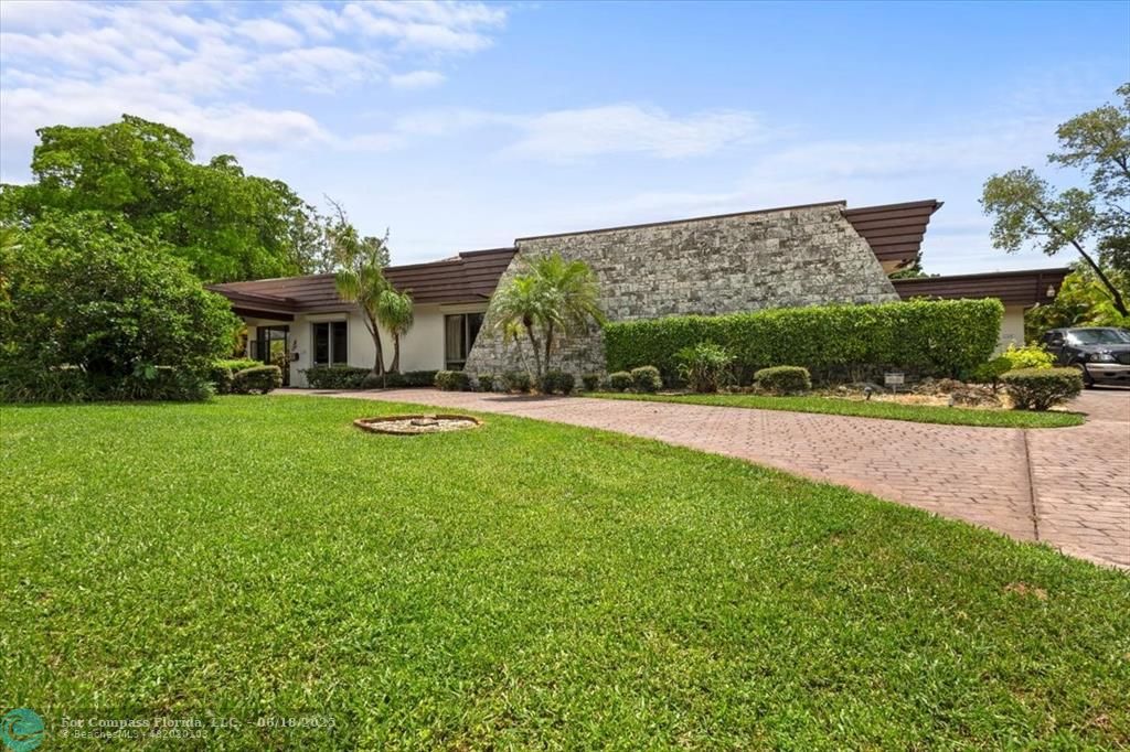 5304 Woodlands Boulevard Tamarac, FL 33319 - Photo 1 of 57 a view of a house with a big yard potted plants and large tree