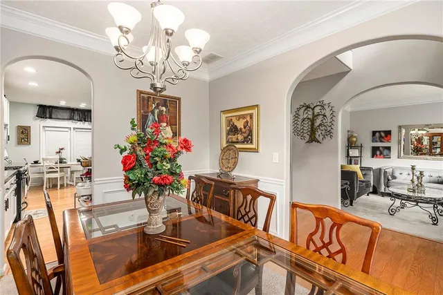 a view of a dining room with furniture a chandelier and wooden floor