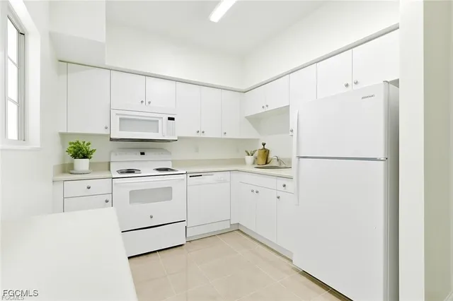 an empty room with a chandelier fan and windows