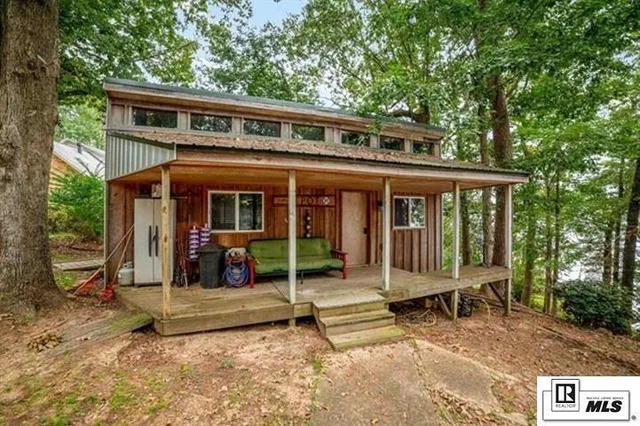 a view of a house with a yard and large tree