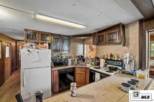 a kitchen with a sink a refrigerator and cabinets