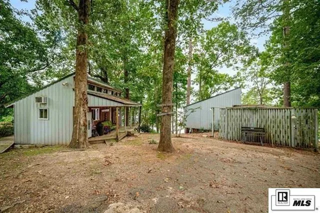 a view of a house with a large tree and wooden fence