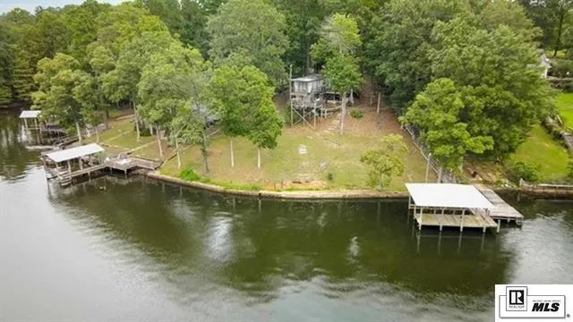 an aerial view of lake residential house with outdoor space and trees around