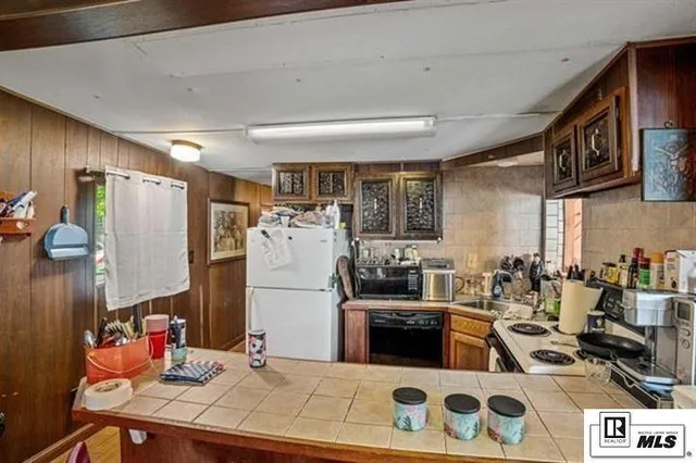 a kitchen with stainless steel appliances kitchen island granite countertop a sink stove and refrigerator