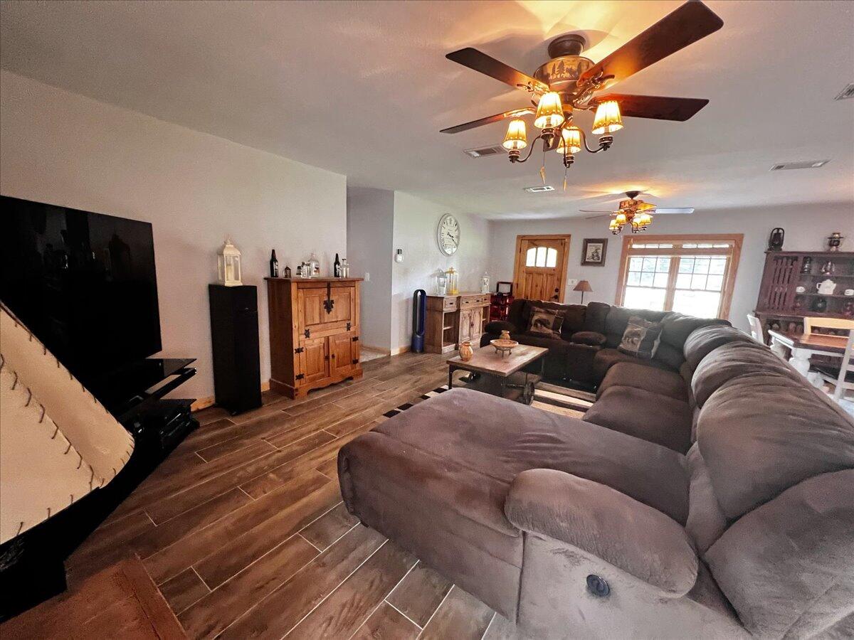 229 Madrid Road Cantonment, FL 32533 - Photo 20 of 84 a living room with furniture a chandelier and a flat screen tv