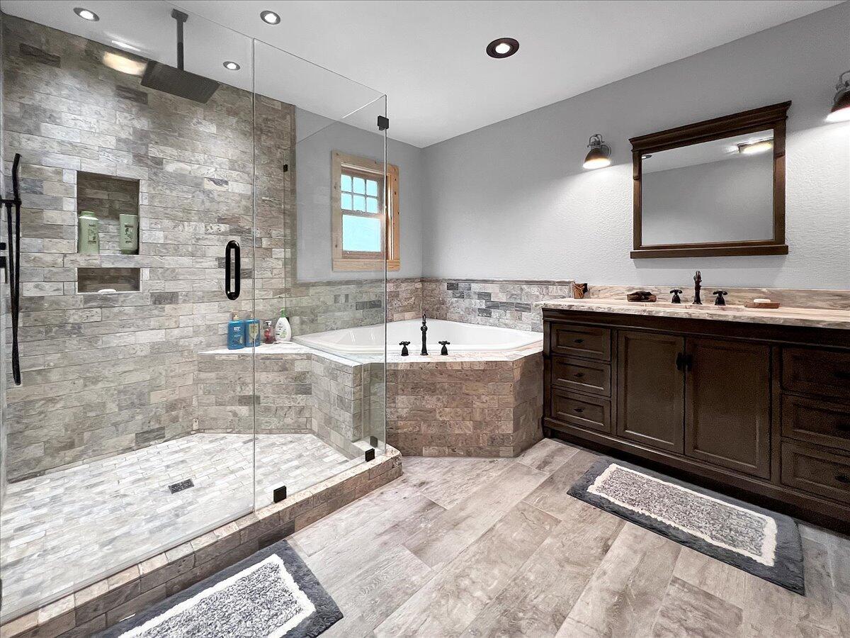 229 Madrid Road Cantonment, FL 32533 - Photo 29 of 84 a bathroom with a tub a double vanity sink and mirror